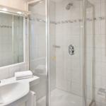Bathroom with shower, sink, and mirror.