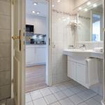 Bathroom with shower, sink, and view into the kitchen.