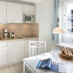 Kitchen with dining area, window, and sailboat model