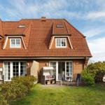 House with red roof, terrace, and garden. Windows and doors are white.