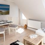 Essbereich mit Tisch, Stühlen und Fernseher unter Dachschrägen