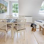Essbereich mit Tisch und Stühlen, Wohnbereich mit Sofa und Dachfenster.