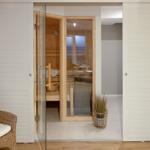 Sauna mit Glasfront und Holzbank. Außerhalb Wickerstuhl mit Handtuch.