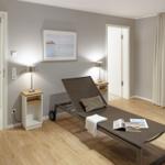 Zimmer mit Liege, Fensterblick aufs Meer und zwei Nachttische mit Lampen.
