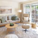 Wohnzimmer mit Sofa, Sessel und Glasfront zur Terrasse.