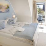 Schlafzimmer mit Bett, Kissen und Blick auf Balkon.