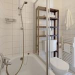 Bad mit Badewanne, Dusche, Toilette und Handtuchhalter.