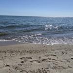 Strand mit Wellen und eingegrabener Schrift DAWNE