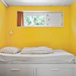 Ein Schlafzimmer mit gelben Wänden, einem Bett und einem Fenster.