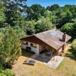 Haus mit Terrasse, Garten und Blick auf den Wald und Meer.