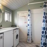 Badezimmer mit Dusche, Waschmaschine und Spiegel