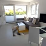 Wohnung mit Küche, Wohnzimmer und Essbereich. Große Fenster und Balkon.