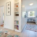 Kitchen with window, bookshelf, and coffee-themed rug.