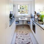 Kitchen with dining area, window, and coffee-themed rug.