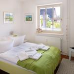 Bedroom with bed, window, and wall pictures