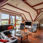 Wohn- und Essbereich mit Sofa, Sesseln und großem Fensterblick.