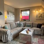 Living room with striped sofa, coffee table, and wall art.