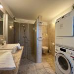 Bathroom with shower, washing machine, and dryer