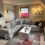 Living room with striped sofa, coffee table, and TV.