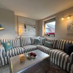 Living room with striped sofa, metal table, and wall art.