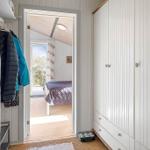 Schlafzimmer mit Bett und Fenster. Kleiderständer und Schrank sind sichtbar.