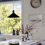 Esstisch mit Vase, Fenster und Wanduhr