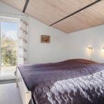 Schlafzimmer mit Doppelbett, Holzdecke und Fenster zur Aussicht.