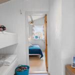 Zimmer mit Doppelstockbetten und Blick auf ein weiteres Schlafzimmer mit Bett.