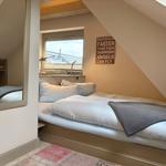 Bedroom with sloped ceiling, bed, window, and wall sign.