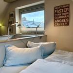Bedroom with bed, window, and wall sign. A sign is on the windowsill.