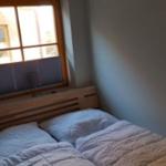 Ein Schlafzimmer mit einem Bett und einem Fenster mit Jalousie.