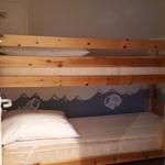 Doppelstockbett mit Matratzen und Kissen. Wandbild mit Fischen und Wellen.