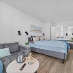 Ein Schlafzimmer mit Sofa, Bett und Fernseher an der Wand.