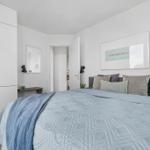 Schlafzimmer mit Bett, Kleiderschrank und Wandbild.