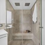Dusche mit Glaswand, Duschbrause und Handtuch