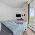 Schlafzimmer mit Bett, TV und Balkonansicht