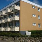 Modern apartment building with balconies and garden area.