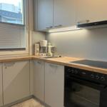 Kitchen with worktop, sink, coffee machine, and stove.