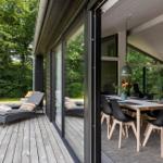 Terrasse mit Liegen und Blick in das Esszimmer mit Tisch und Stühlen.