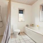 Badezimmer mit Badewanne, Dusche, Toilette und Waschmaschine.