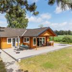 Holzhütte mit Terrasse, Garten und Blick auf Felder.