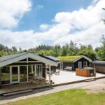 Moderne Holzhütte mit Terrasse, Whirlpool und Sauna im Wald.