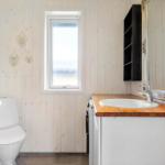 Badezimmer mit Toilette, Waschbecken und Fenster