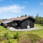 Schwarzes Holzhaus mit Terrasse und Garten. Modernes Design mit großem Fensterbereich.