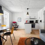 Wohnung mit Essbereich, Küche und Sofa. Holzboden, große Fenster und moderne Beleuchtung.