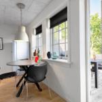 Essbereich mit Tisch und Stühlen, Fenster und Tür zum Garten.