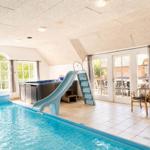 Innenpool mit Rutsche und Whirlpool, großzügiger Raum mit Fenstern und Terrasse.