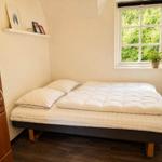Ein Schlafzimmer mit Bett, Fenster und Kleiderschrank.