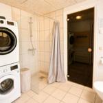 Dusche mit Duschvorhang, Waschmaschine und Trockner im Bad