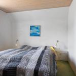 Schlafzimmer mit Bett, Fenster, Wandbild und Stehlampe.